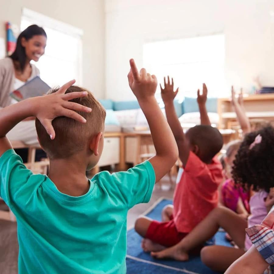 Children pointing at pictures in a book.